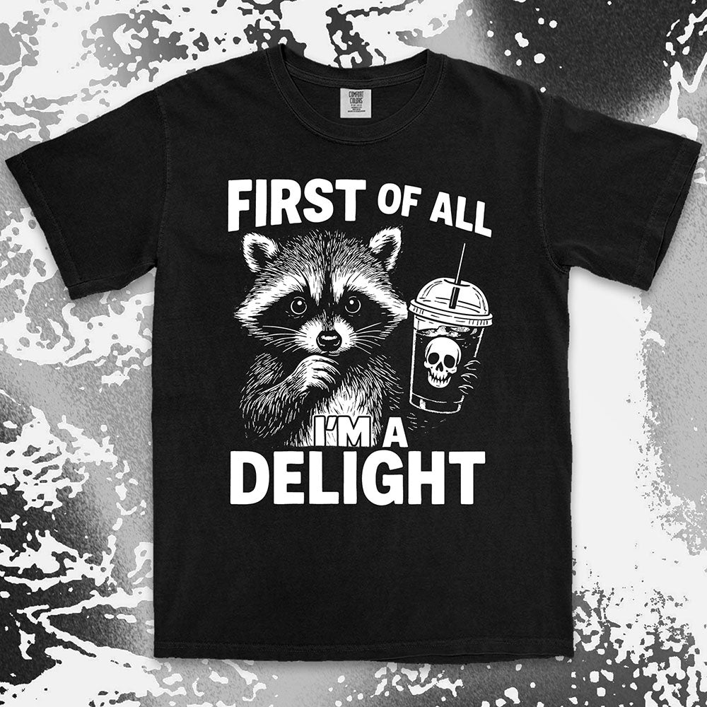 Comfort Color t-shirt with raccoon holding a spooky cup and bold text “First of all I’m a delight.”
