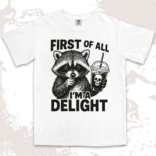 Comfort Color t-shirt with raccoon holding a spooky cup and bold text “First of all I’m a delight.”