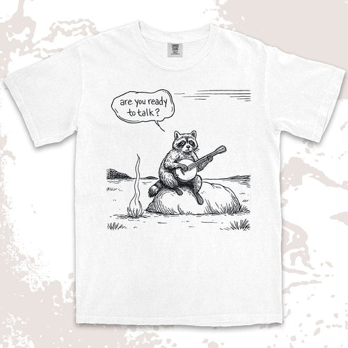 Comfort Color t-shirt with raccoon playing banjo by campfire and speech bubble saying “Are you ready to talk?”