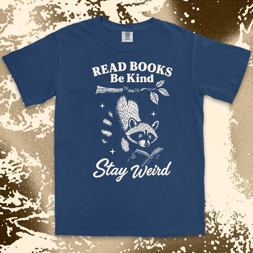 Comfort Color t-shirt with raccoon hanging from a branch reading a book and quote ÒRead books be kind stay weirdÓ printed in vintage style.