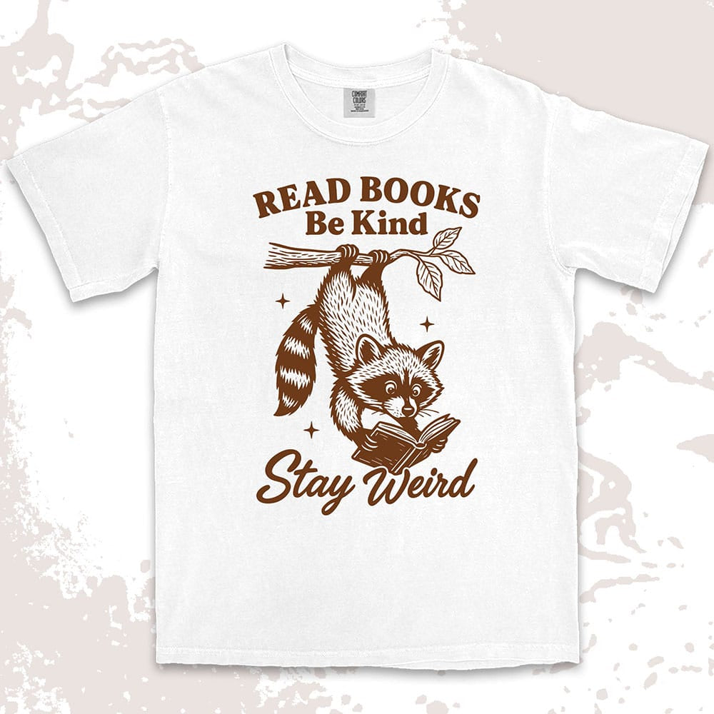 Comfort Color t-shirt with raccoon hanging from a branch reading a book and quote ÒRead books be kind stay weirdÓ printed in vintage style.
