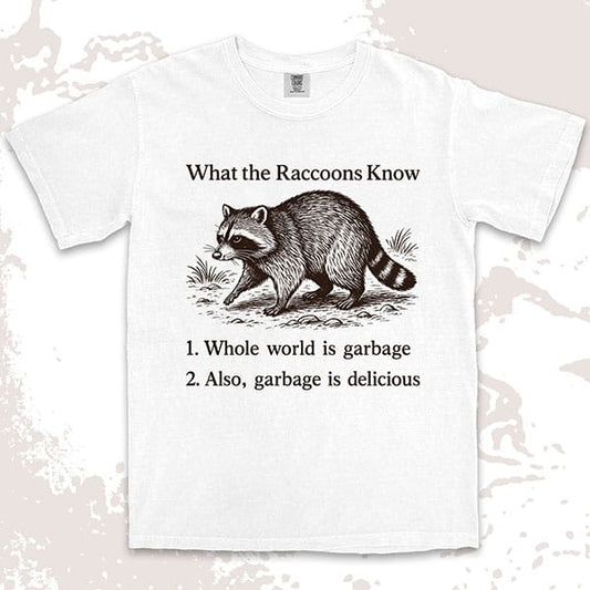 Comfort Color t-shirt with raccoon illustration and quote “What the Raccoons Know – Whole world is garbage, garbage is delicious.”