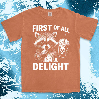Comfort Color t-shirt with raccoon holding a spooky cup and bold text “First of all I’m a delight.”