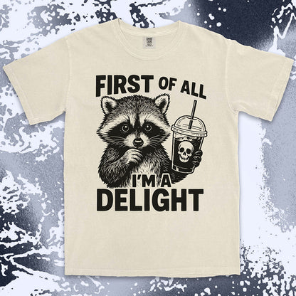 Comfort Color t-shirt with raccoon holding a spooky cup and bold text “First of all I’m a delight.”
