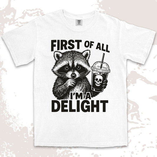 Comfort Color t-shirt with raccoon holding a spooky cup and bold text “First of all I’m a delight.”