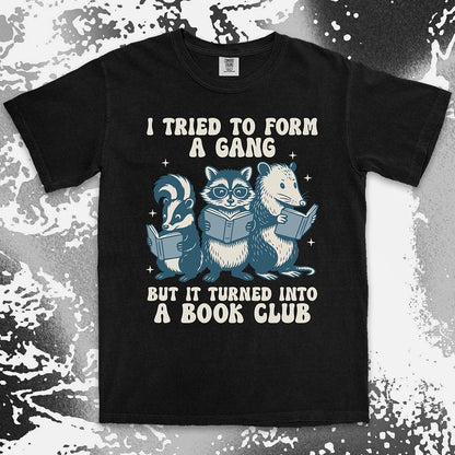 Comfort Color t-shirt with raccoon, skunk, and possum reading books and quote “I tried to form a gang but it turned into a book club.”