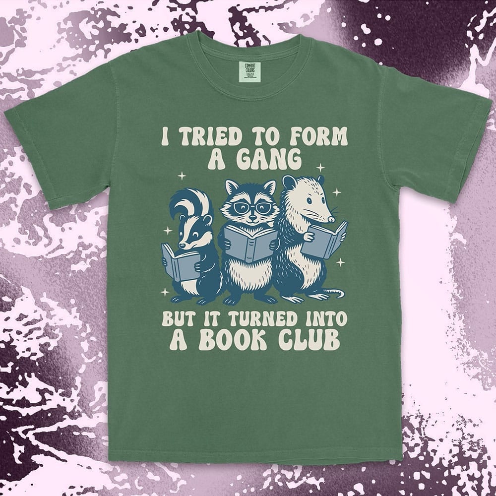 Comfort Color t-shirt with raccoon, skunk, and possum reading books and quote “I tried to form a gang but it turned into a book club.”