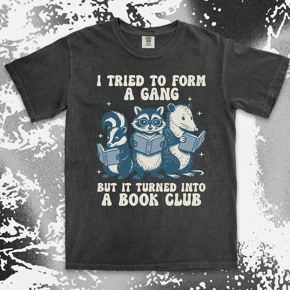Comfort Color t-shirt with raccoon, skunk, and possum reading books and quote “I tried to form a gang but it turned into a book club.”