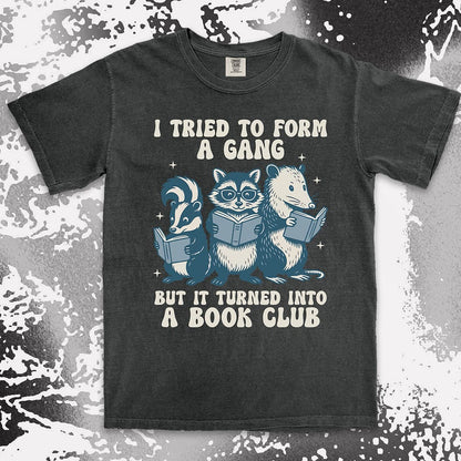 Comfort Color t-shirt with raccoon, skunk, and possum reading books and quote “I tried to form a gang but it turned into a book club.”