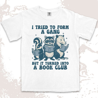 Comfort Color t-shirt with raccoon, skunk, and possum reading books and quote “I tried to form a gang but it turned into a book club.”