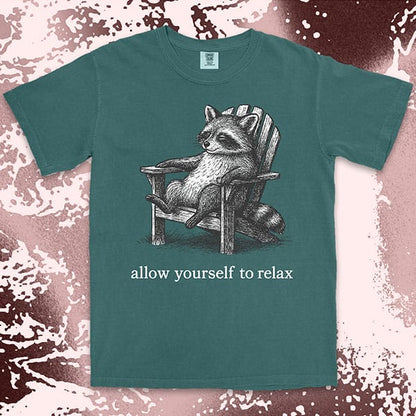 Comfort Color t-shirt with raccoon lounging on a chair and text “Allow yourself to relax” in a calm design.
