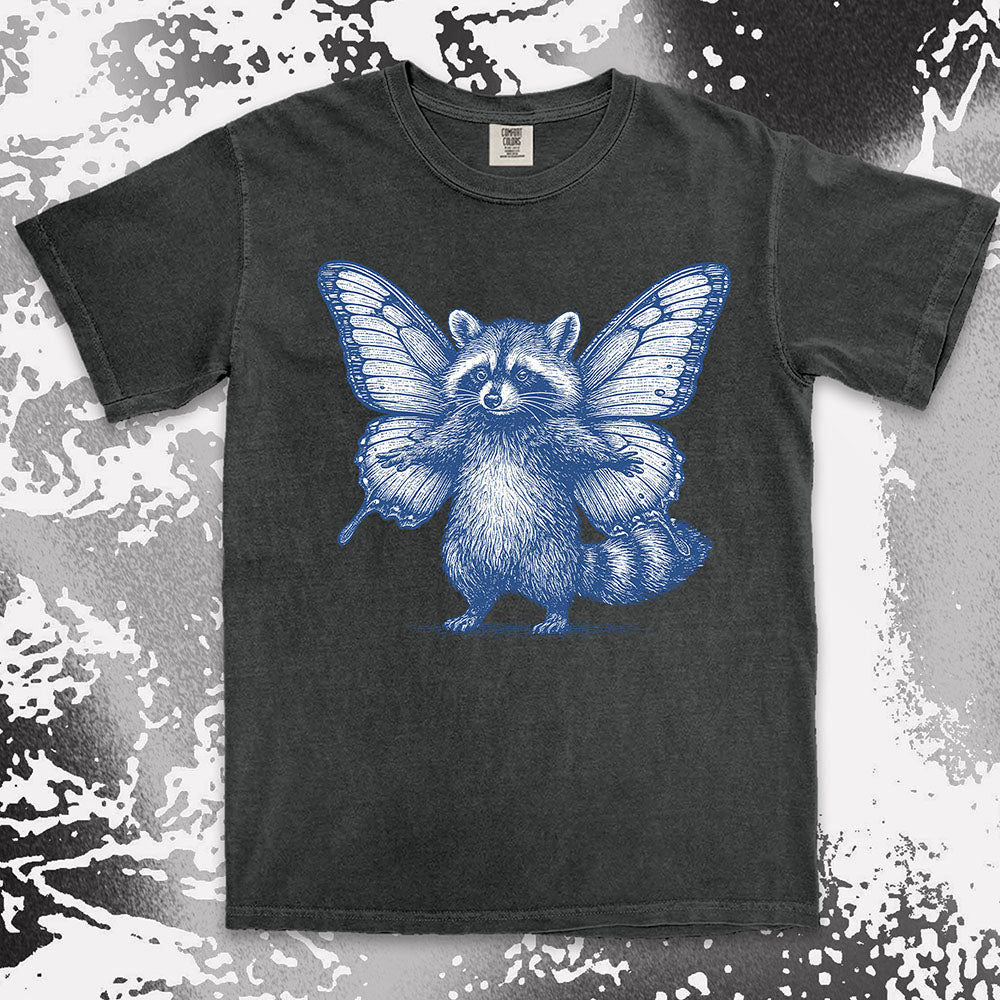Comfort Color t-shirt with raccoon illustration featuring big butterfly wings in a magical fairy style.