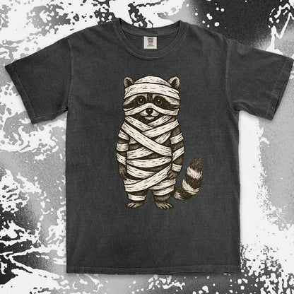 Comfort Color t-shirt with raccoon dressed as a mummy wrapped in bandages for Halloween.