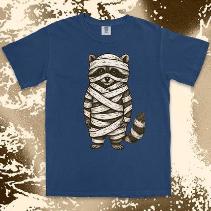 Comfort Color t-shirt with raccoon dressed as a mummy wrapped in bandages for Halloween.