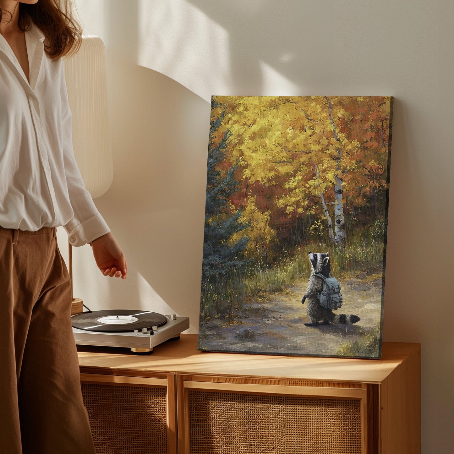 Autumn raccoon canvas wall art featuring a raccoon with backpack walking on forest path surrounded by yellow and orange fall trees