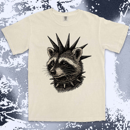 Beige t-shirt with a raccoon design wearing a spiked collar on a textured surface. Ivory color shirt