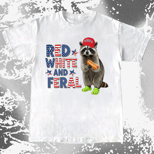 Patriotic raccoon wearing red hat and green Crocs holding a hot dog, text “Red White and Feral”, humorous feral Americana vibe