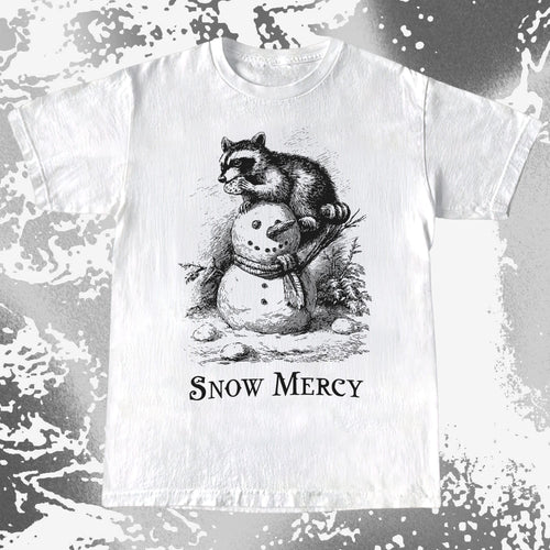 White t-shirt with a graphic of a raccoon on a snowman and 'Snow Mercy' text, against a distressed white and gray background.