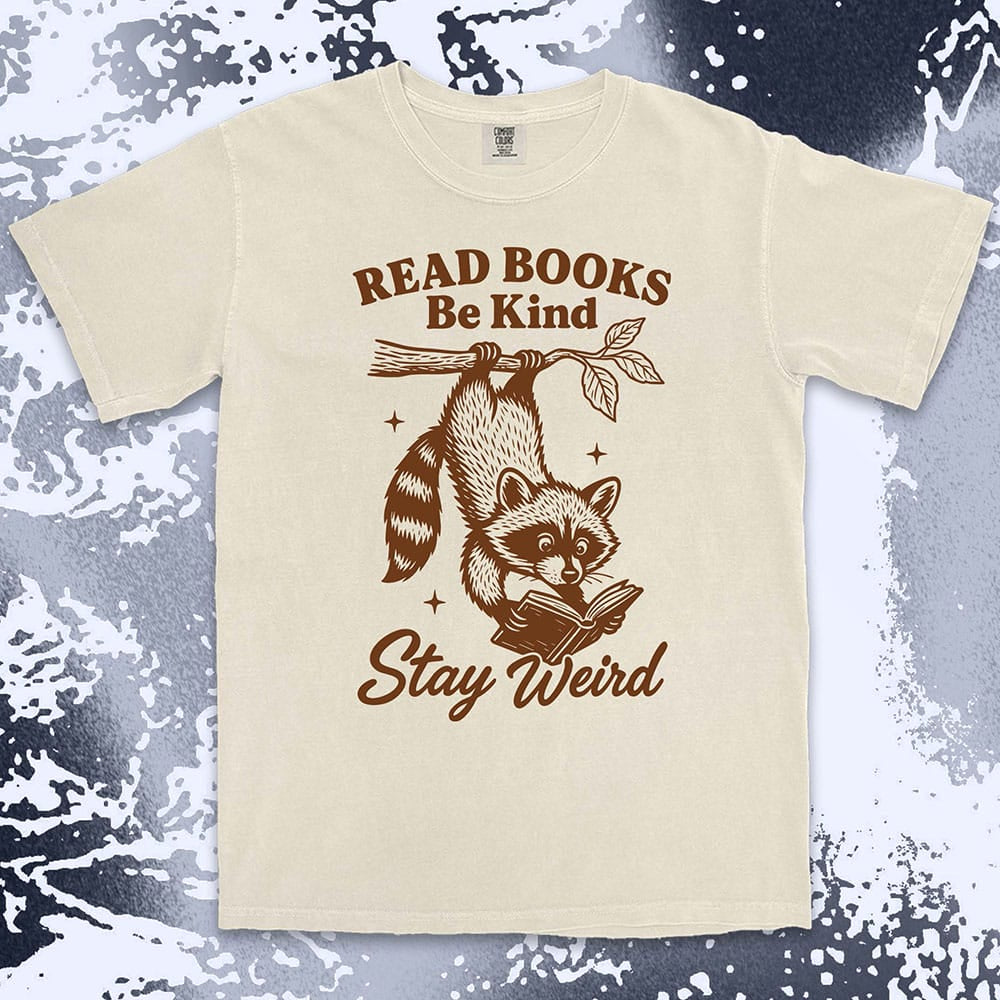 Comfort Color t-shirt with raccoon hanging from a branch reading a book and quote ÒRead books be kind stay weirdÓ printed in vintage style.