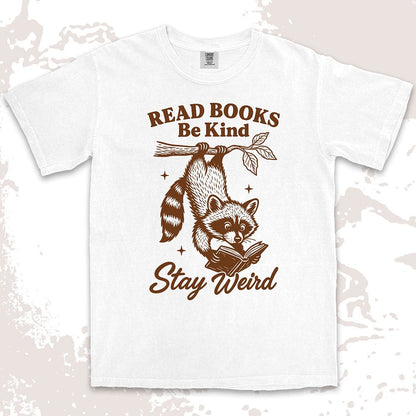 Comfort Color t-shirt with raccoon hanging from a branch reading a book and quote ÒRead books be kind stay weirdÓ printed in vintage style.